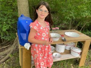 Emry in mud kitchen